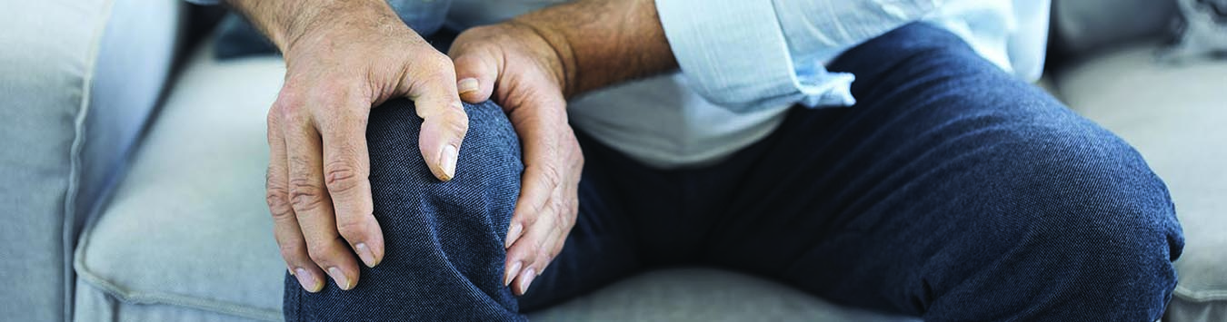 Man with pain holding knee